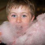 A young boy eating candyfloss