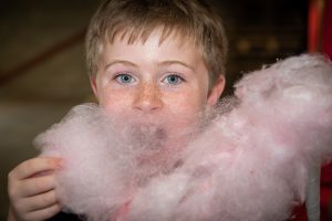 A young boy eating candyfloss