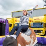 A guest at W.S. Dennison's 40th anniversary celebration having fun on a rodeo bull